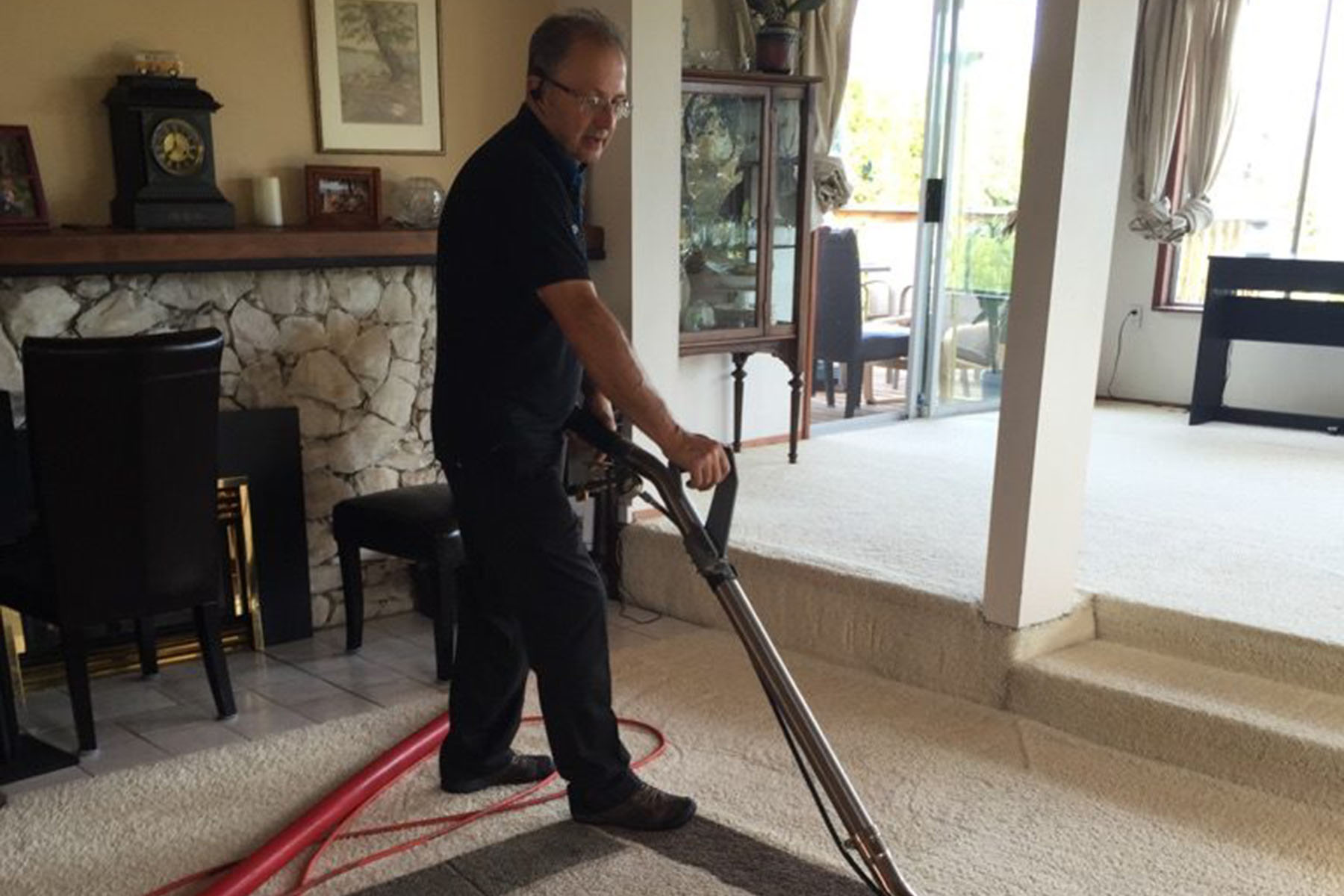 Technician using advanced equipment to clean a carpet in a family home.